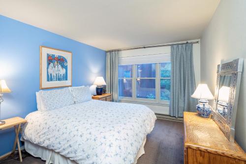 a blue bedroom with a bed and a window at Cozy Condo steps to Coonskin lift in Telluride