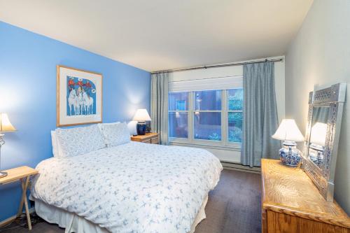 een blauwe slaapkamer met een bed en een raam bij Cozy Condo steps to Coonskin lift in Telluride