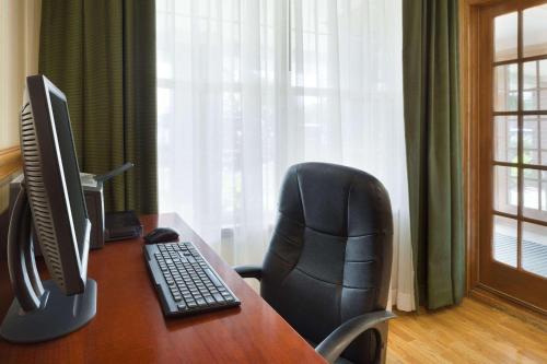 a desk with a computer monitor and a chair at Country Inn & Suites by Radisson, Macedonia, OH in Macedonia
