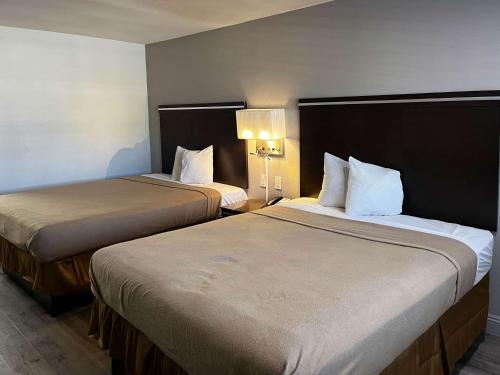 two beds in a hotel room next to each other at Studio 6 Artesia CA in Artesia