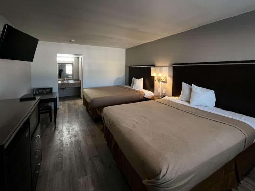 Habitación de hotel con 2 camas y escritorio en Studio 6 Artesia CA en Artesia