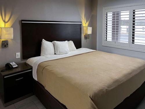 a bedroom with a large bed and a window at Studio 6 Artesia CA in Artesia