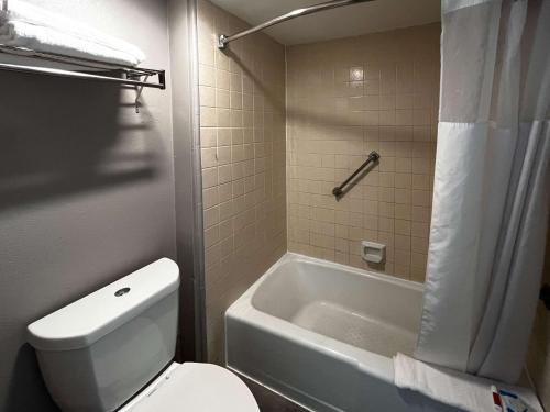 a bathroom with a white toilet and a bath tub at Studio 6 Artesia CA in Artesia