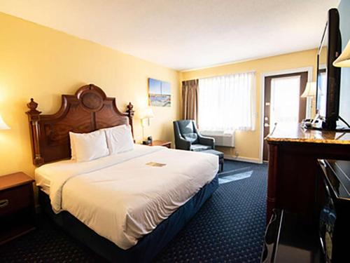 a hotel room with a bed and a television at Fireside Inn, Ocean's Edge in Belfast