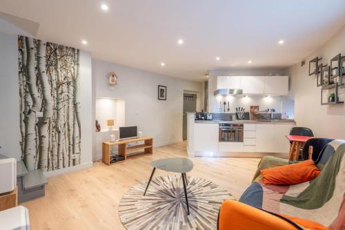 un salon avec un canapé et une table et une cuisine dans l'établissement Le Passage du Château, à Annecy