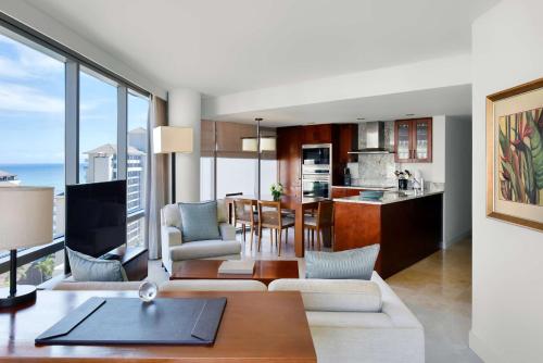 a living room with a kitchen and a dining room at Ka La'i Waikiki Beach, LXR Hotels & Resorts in Honolulu