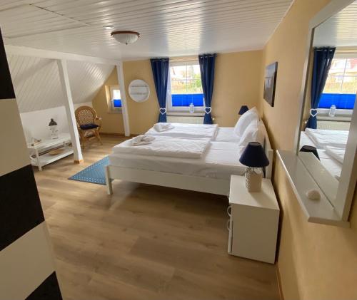 een slaapkamer met een groot wit bed en 2 ramen bij Reethaus Vilmnitz - Ferienwohnung Goor in Vilmnitz