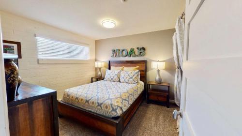 1 dormitorio con 1 cama y un cartel en la pared en Downtown Cozy Home Base - Purple Sage 3 en Moab