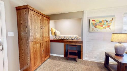 Cette petite chambre comprend une armoire en bois et un bureau. dans l'établissement Downtown Cozy Home Base - Purple Sage 3, à Moab