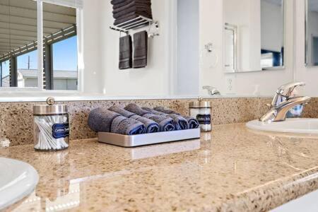 um banheiro com uma bancada com duas pias e dois espelhos em Luxurious Getaway Near Coachella Stagecoach Pool Putting Green Parking Firepit Sleeps 11 em Indio