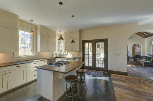 a kitchen with white cabinets and a island with bar stools at South Main Residences by Surf Hotel in Buena Vista