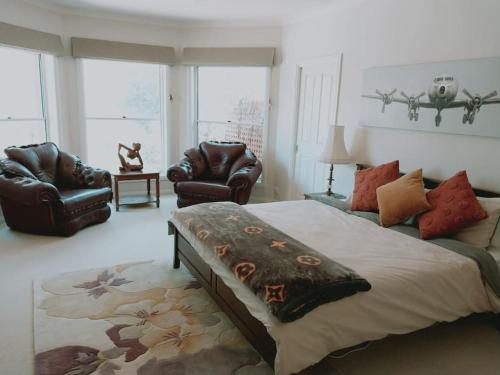 a bedroom with a large bed and two chairs at Downing Estate Homestead in Heathcote