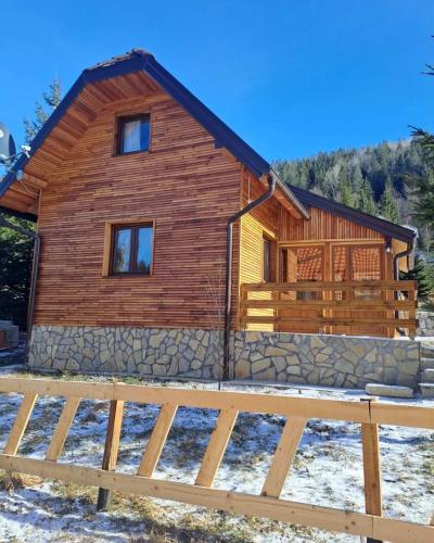 a log cabin with a fence in front of it at Vikendica Kraljica planina in Konjska Reka