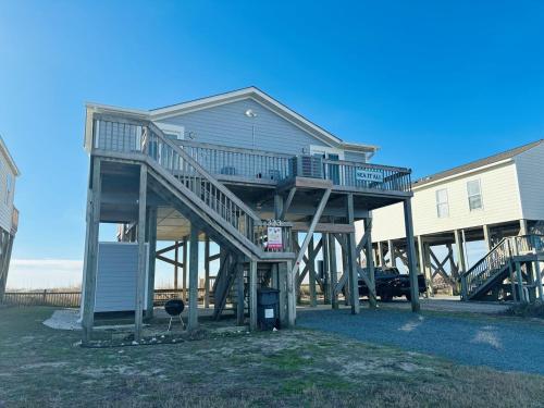 a house with a staircase leading up to it at Sea It All Home in Varnamtown