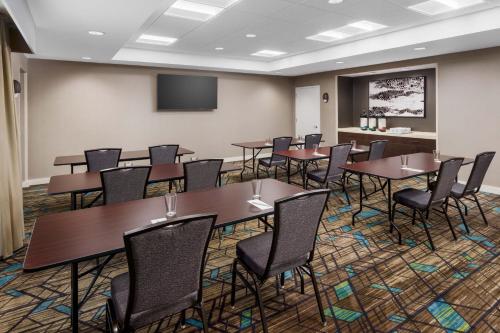 a conference room with tables and chairs and a screen at Residence Inn by Marriott New Haven Hamden in Hamden