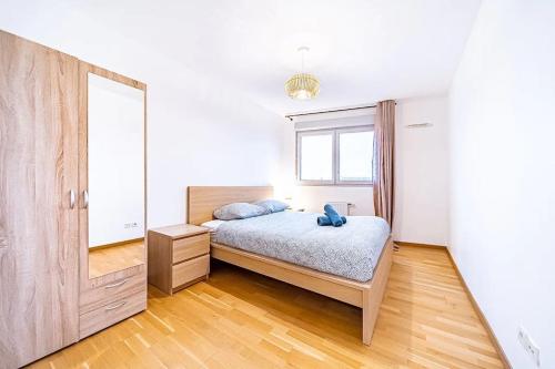 une chambre avec un lit et un grand miroir dans l'établissement Joli T2 avec garage gratuit et balcon, à Villeurbanne