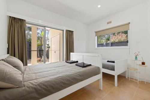 CorinellaにあるForeshore Retreatのベッドと窓のある白い寝室