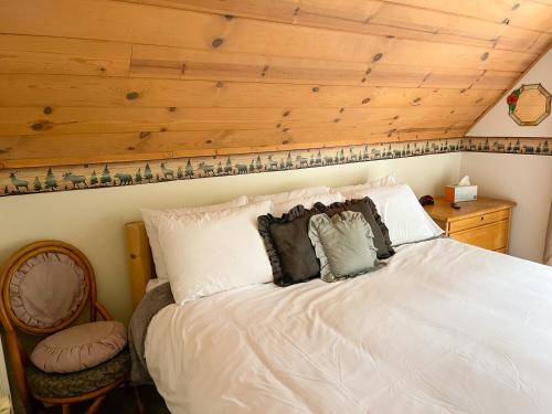 een slaapkamer met een wit bed en een houten plafond bij A-Frame Cabin in The Sequoias in Wofford Heights