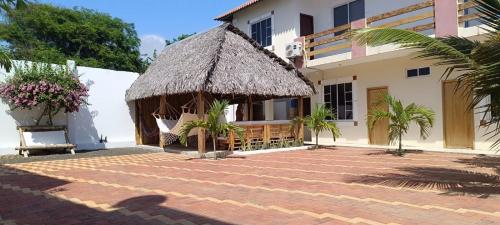 a building with a thatch roof and a courtyard at Casa Veranera Beach in Hacienda San Clemente