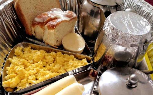 a tray of food with eggs and bread on a table at Suite Guarujá in Guarujá