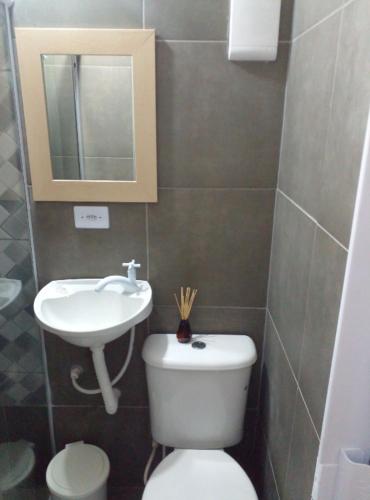 Baño pequeño con aseo y lavamanos en Suite Guarujá, en Guarujá