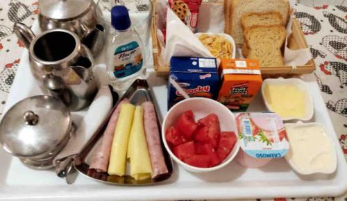 una bandeja de comida con queso, fruta y pan en Suite Guarujá en Guarujá