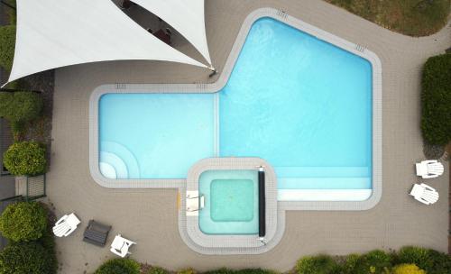 an overhead view of a swimming pool with tables and chairs at Suncourt Hotel & Conference Centre in Taupo