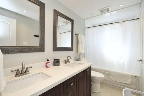 a bathroom with a sink and a toilet and a mirror at Barrie House near to all amenities in Barrie