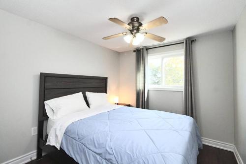 a bedroom with a bed with a ceiling fan at Barrie House near to all amenities in Barrie