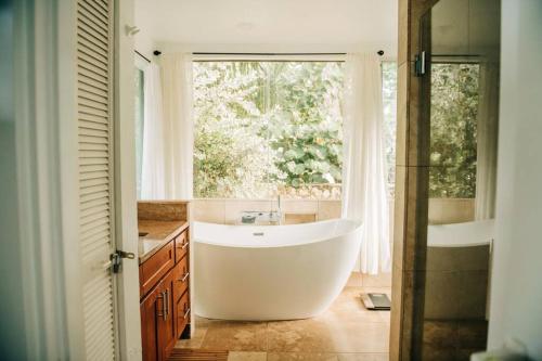 a bath tub in a bathroom with a window at Beach Front/Free Breakfast/Hawaiian Retreat/Luxury in Hauula