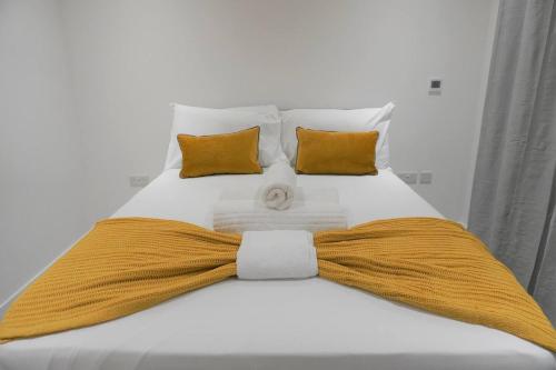 a bed with a yellow bow tie on it at Queens Luxury Apartments Wembley Stadium - London in London