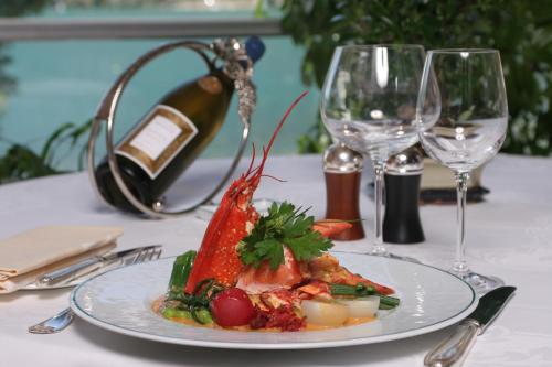 a plate of food on a table with wine glasses at Logis Hotel L'Embarcadère in Nantua