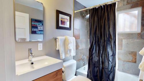 a bathroom with a sink and a toilet and a mirror at Downtown Cozy Home Base - Purple Sage 5 in Moab