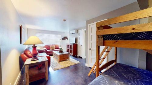 a bedroom with a bunk bed and a living room at Downtown Cozy Home Base - Purple Sage 5 in Moab