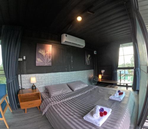 1 dormitorio con 1 cama con 2 toallas en Little Farm Nakornnayok, 