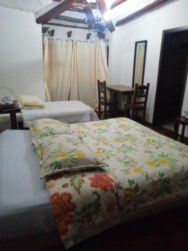 um quarto com 2 camas e uma mesa com cadeiras em Hotel Salamandra Tunja em Tunja