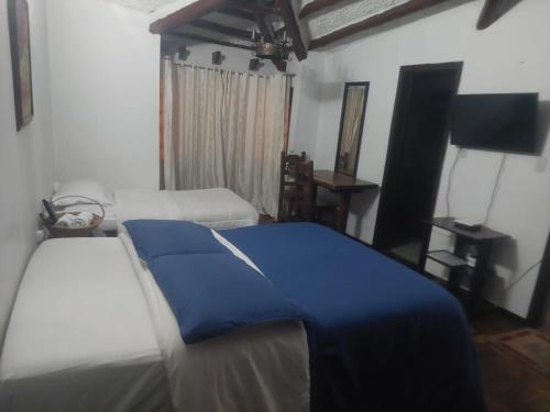 - une chambre avec 2 lits et une couverture bleue dans l'établissement Hotel Salamandra Tunja, à Tunja