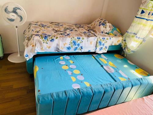 a small bedroom with a bed and a fan at Aparta Hotel Manzur in Barranquilla