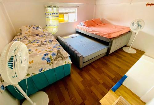 um pequeno quarto com 2 camas e uma ventoinha em Aparta Hotel Manzur em Barranquilla