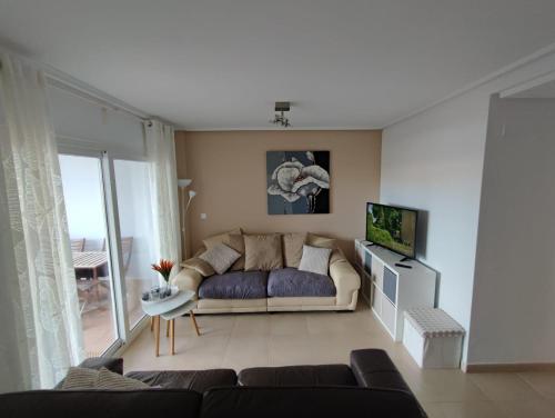 a living room with a couch and a tv at Hacienda Riquelme Golf Resort Ground Floor Apartment Sucina Murcia in Murcia