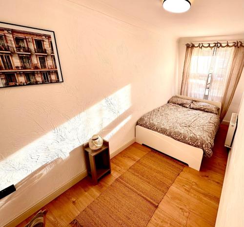um pequeno quarto com uma cama e uma janela em Flat 6 Stay In Aldgate em Londres