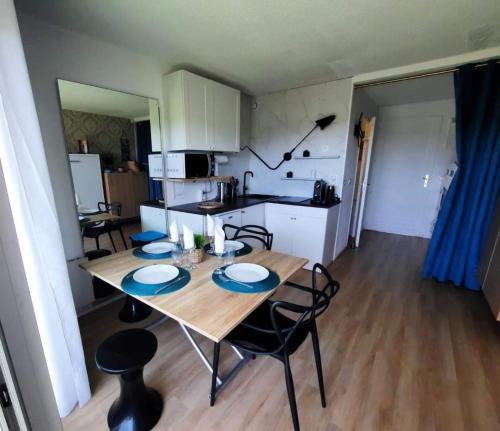 une cuisine et une salle à manger avec une table et des chaises en bois dans l'établissement Studio with pool in Guérande, à Guérande