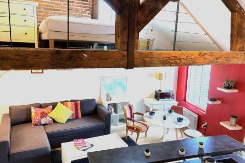 - un salon avec un canapé et un lit dans l'établissement Le Tripode-Hypercentre au calme et atypique, à Nantes