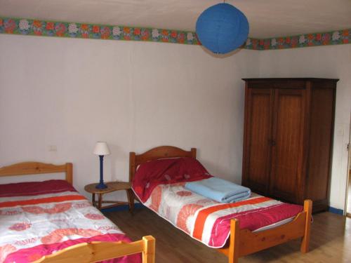 een slaapkamer met 2 bedden en een tafel met een lamp bij Tavaud in Dournazac