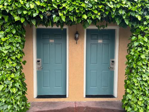 two blue doors on the side of a building with ivy at Monterey Oceanside Inn in Monterey