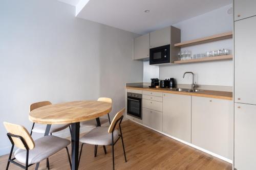 une petite cuisine avec une table et des chaises en bois dans l'établissement Beautiful Minimalist 1BD Apartment near Montmartre, à Paris