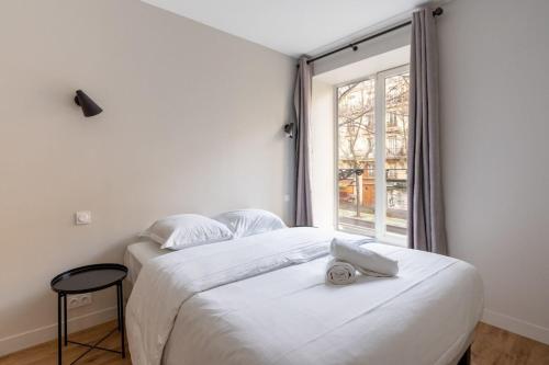 une chambre avec deux lits et une fenêtre dans l'établissement Beautiful Minimalist 1BD Apartment near Montmartre, à Paris