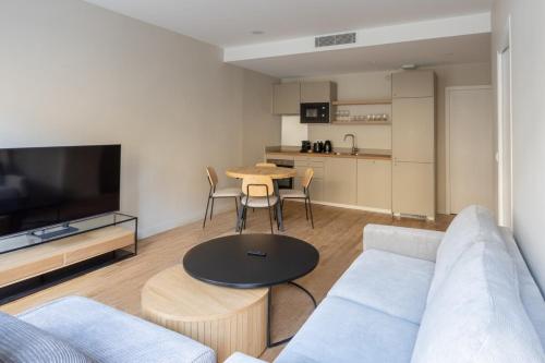 un salon avec un canapé et une table dans l'établissement Beautiful Minimalist 1BD Apartment near Montmartre, à Paris