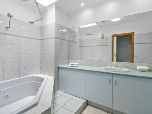 a white bathroom with a tub and a sink at Yarrawonga Lakeside Apartment 44 in Mulwala