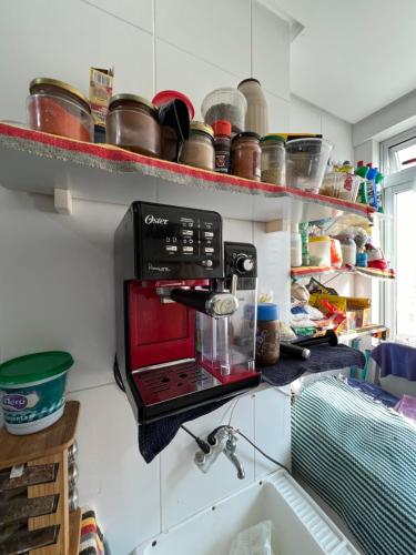 a kitchen with a coffee maker on a wall at Apartamento Próximo Ao Centro MultiUso São José in São José